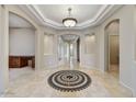 Grand foyer boasts travertine floors, mosaic inlay, tray ceilings, and archways, adding architectural detail at 34014 N 43Rd St, Cave Creek, AZ 85331