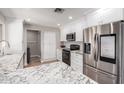 Bright kitchen with stainless steel appliances, granite countertops, white cabinets, and recessed lighting at 3503 E Campo Bello Dr, Phoenix, AZ 85032