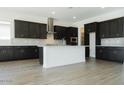 Modern kitchen with dark wood cabinets, stainless steel appliances, white countertops, and wood-look tile flooring at 3951 E Gold Mountain Ave, San Tan Valley, AZ 85143