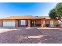 Single-story brick home features a well-maintained yard, attached garage, and brick walkway at 4323 W Villa Theresa Dr, Glendale, AZ 85308