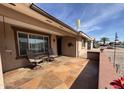 Relaxing covered patio featuring flagstone tile, outdoor seating and a view of the neighborhood at 4530 E Dragoon Ave, Mesa, AZ 85206