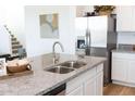 Kitchen island with granite countertops and a stainless steel sink and faucet at 5826 S Daisy Patch Pl, Phoenix, AZ 85040