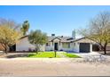 Charming single-story home featuring a well-manicured lawn and desert landscaping at 6325 N 83Rd Pl, Scottsdale, AZ 85250