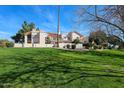 Inviting condo building showcasing lush lawn and mature trees on a sunny day with clear blue skies at 7800 E Lincoln E Dr # 1102, Scottsdale, AZ 85250