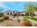 Charming home featuring desert landscaping, a stone pathway, and a spacious three-car garage at 891 W Palo Brea Dr, Litchfield Park, AZ 85340