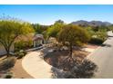 Gorgeous aerial view of home featuring circular driveway, lush landscaping, and mature trees at 9901 N 51St Pl, Paradise Valley, AZ 85253