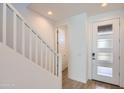 Bright entryway with white banister, neutral-toned flooring, and a modern front door with glass panels at 10209 E Ursula Ave, Mesa, AZ 85212