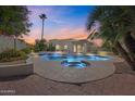 A backyard pool glows at dusk, complimented by lush landscaping to create a tranquil outdoor oasis at 10540 N 78Th Pl, Scottsdale, AZ 85258