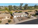 Aerial view of single-story home with desert landscaping, next to a golf course and tree-lined neighborhood at 10846 W Crosby Dr, Sun City, AZ 85351