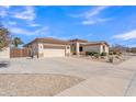 Spacious three car garage, expansive driveway, and desert landscaping at 14612 W Edgemont Ave, Goodyear, AZ 85395