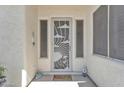 Front door entrance featuring a decorative security door, tiled floor, and desert-themed decor at 14612 W Edgemont Ave, Goodyear, AZ 85395