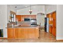 Bright kitchen with wood cabinets, granite countertops, stainless steel appliances, and breakfast bar at 16029 N 36Th Dr, Phoenix, AZ 85053