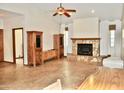 Open living room features a stone fireplace, light walls, neutral carpet, and ceiling fan at 16029 N 36Th Dr, Phoenix, AZ 85053