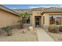 Inviting entryway with decorative security door and meticulously maintained desert landscaping with gravel at 16051 W Desert Winds Dr, Surprise, AZ 85374