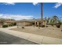 Lovely home with desert landscaping, palm trees, and a two-car garage under a vibrant blue sky at 16051 W Desert Winds Dr, Surprise, AZ 85374