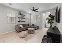 A cozy living room with a modern ceiling fan, plush gray sectional, and stylish decor at 1677 E Bridgeport Pkwy, Gilbert, AZ 85295