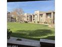 View of manicured lawn and attractive apartments at a complex with well-maintained landscaping at 17017 N 12Th St # 1135, Phoenix, AZ 85022