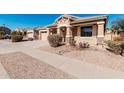 Lovely single-Gathering home boasts desert landscaping, a covered porch, and an attached garage at 17642 W Pershing St, Surprise, AZ 85388