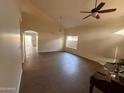 Open living room featuring wood floors, vaulted ceiling, ceiling fan, and a large window for plenty of natural light at 2016 S 66Th Ln, Phoenix, AZ 85043