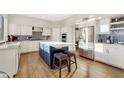 Bright kitchen featuring white cabinets, navy blue island, stainless steel appliances, and modern tile backsplash at 21915 N 65Th Ave, Glendale, AZ 85310