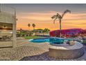 Inviting backyard with a sparkling pool, lush tropical plants, and a cozy outdoor seating area at 21915 N 65Th Ave, Glendale, AZ 85310