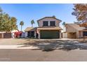 Charming two-story home featuring a spacious driveway, desert landscaping, and mature palm trees at 24021 N 39Th Ln, Glendale, AZ 85310