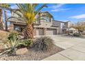 Two story stucco home with a three car garage, desert landscaping, and a large palm tree at 29740 W Fairmount Ave, Buckeye, AZ 85396