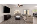 Bright living room featuring neutral walls, a ceiling fan, a decorative rug, and sliding glass doors to the backyard at 3034 E Coconino Dr, Gilbert, AZ 85298