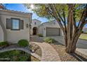 Beautiful home featuring a brick walkway, lush landscaping, and a manicured lawn, radiating curb appeal at 30488 N 126Th Dr, Peoria, AZ 85383