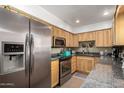 Well-equipped kitchen showcases stainless steel appliances, including refrigerator, oven, microwave and granite countertops with ample wood cabinetry at 3655 N 5Th Ave # 213, Phoenix, AZ 85013