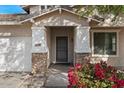 Close-up of home's entrance with stone accents on columns, bougainvillea and a well-manicured lawn at 3746 E Vallejo Dr, Gilbert, AZ 85298