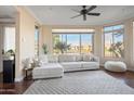 Bright living room with large bay window, hardwood flooring, and a comfortable white couch at 4931 N Woodmere Fairway -- # 1001, Scottsdale, AZ 85251