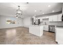 A modern kitchen with stainless steel appliances, white cabinets, and a stylish island, perfect for cooking and entertaining at 5919 W Villa St, Phoenix, AZ 85043