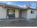 Inviting front porch featuring gray tiled floors and a cozy, cushioned seating area at 6532 N 60Th N Ave, Glendale, AZ 85301