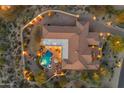 Stunning aerial view of the estate, showcasing its private pool, outdoor lighting, and expansive grounds at 8320 E Arroyo Hondo Rd, Scottsdale, AZ 85266