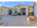 Inviting front entrance featuring a paver courtyard, comfortable seating, and lush plantings at 8320 E Arroyo Hondo Rd, Scottsdale, AZ 85266