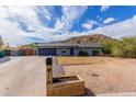 Single-story home featuring desert landscaping, a mountain in the background and a mailbox planter under a cloudy, blue sky at 9005 E Grandview Dr, Mesa, AZ 85207