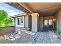 Inviting entryway featuring a stone and gravel path and a covered porch with decorative pillars and double doors at 9739 E Pershing Ave, Scottsdale, AZ 85260