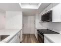 Modern kitchen with white cabinets, quartz countertops, stainless steel appliances, and new wood-look floors at 1021 S Greenfield Rd # 1001, Mesa, AZ 85206