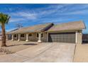 Well-maintained single-story home with desert landscaping, a tiled roof, and an attached two-car garage at 1318 E Mission Grande Ave, Casa Grande, AZ 85122