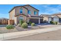 A landscaped two-story home showing the front yard and a three-car garage on a sunny day at 13307 W Paso Trl, Peoria, AZ 85383