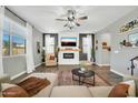 Comfortable living room featuring a fireplace, ceiling fan, and stylish furnishings at 13307 W Paso Trl, Peoria, AZ 85383