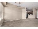 Open living room featuring a large window, neutral walls and carpet, and an open access to the kitchen at 14575 W Mountain View Blvd # 11221, Surprise, AZ 85374