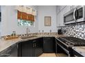 Modern kitchen with stainless steel appliances, mosaic backsplash, and stylish countertops at 1531 S Owl Dr, Gilbert, AZ 85296