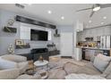 Open-concept living room features sleek shelving, modern furniture, and an adjacent kitchen with stainless steel appliances at 1531 S Owl Dr, Gilbert, AZ 85296