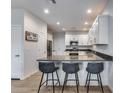 Well-lit kitchen with quartz countertops, white cabinetry, and bar stool seating at 2030 E Michigan Ave # 9, Phoenix, AZ 85022