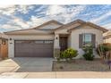 Well-maintained one-story house featuring desert landscaping, a two-car garage, and a covered front entryway at 25610 N 144Th Ln, Surprise, AZ 85387
