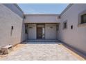 Front entrance of a modern home featuring stone pavers and a stylish wood door at 28304 N 141St Way, Scottsdale, AZ 85262