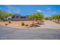 Modern home exterior with desert landscaping, trees, and circular driveway leading to the property at 28304 N 141St Way, Scottsdale, AZ 85262