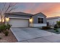 View of the inviting facade of this home featuring a two car garage and a long driveway at 30071 W Indianola Ave, Buckeye, AZ 85396